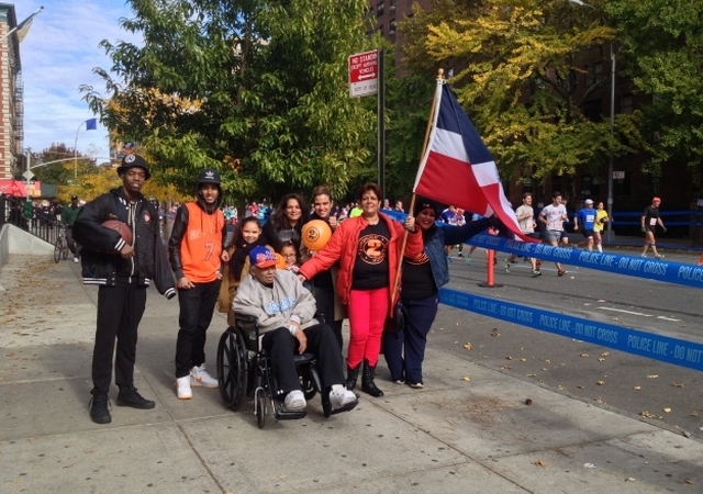 Luz Estrella, junto a su familia, carga la bandera dominicana cerca de la milla 21 en Harlem donde esperó a su hijo, Nelson Flores, que corrió la maratón para recaudar fondos para la lucha contra la leucemia. Foto: Gustavo Martínez/EDLP