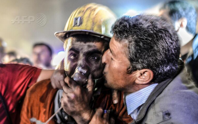 Hombre besa a su hijo rescatado. Via Twitter.com/AFP