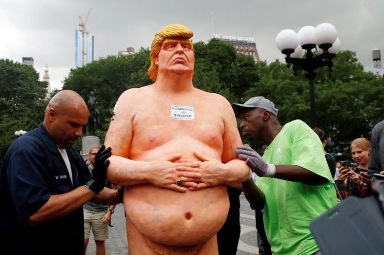 New York City Parks workers move a naked statue of U.S. Republican presidential nominee Donald Trump that was left in Union Square Park in New York
